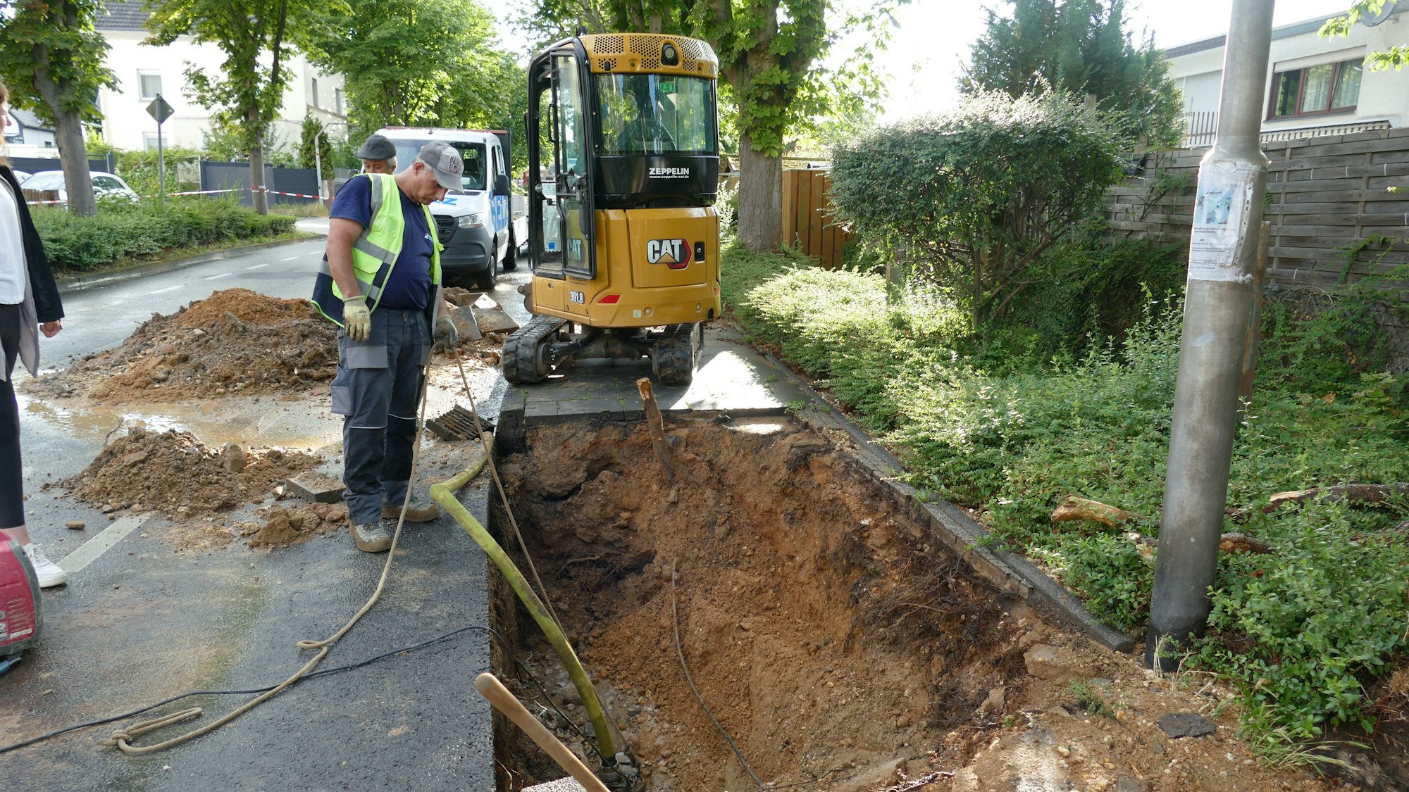 Mitarbeiter der Stadtwerke suchten sofort nach dem Leck in der Hauptwasserleitung. Einer steht vor dem Loch in der Straße.
