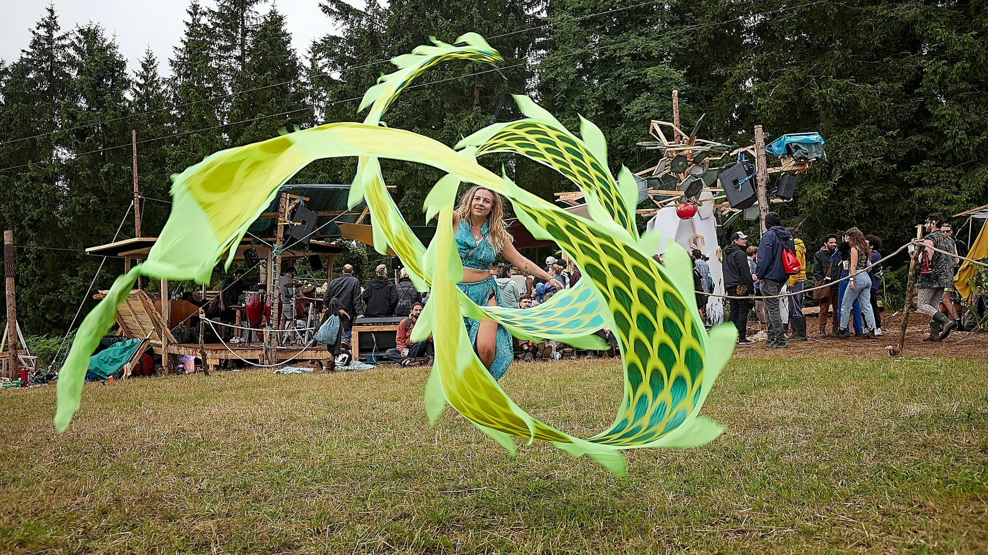 Eine Frau wirbelt ein meterlanges Tuch an einem Stab durch die Luft.