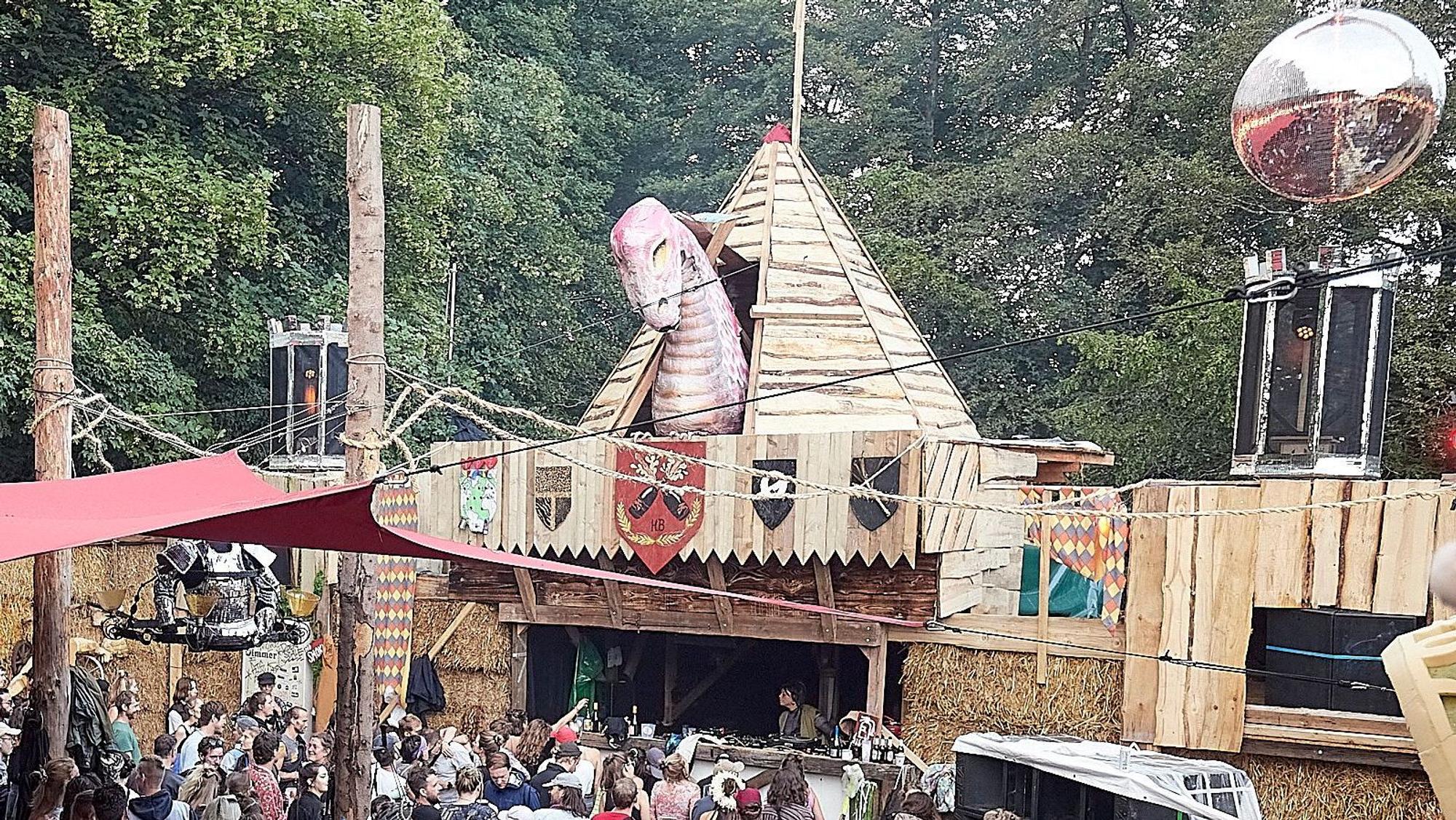Aufwendig ist das gesamte Festival-Gelände gestaltet, hier eine Tanzarena, die mit einer großen Dinosaurier-Figur dekoriert ist.