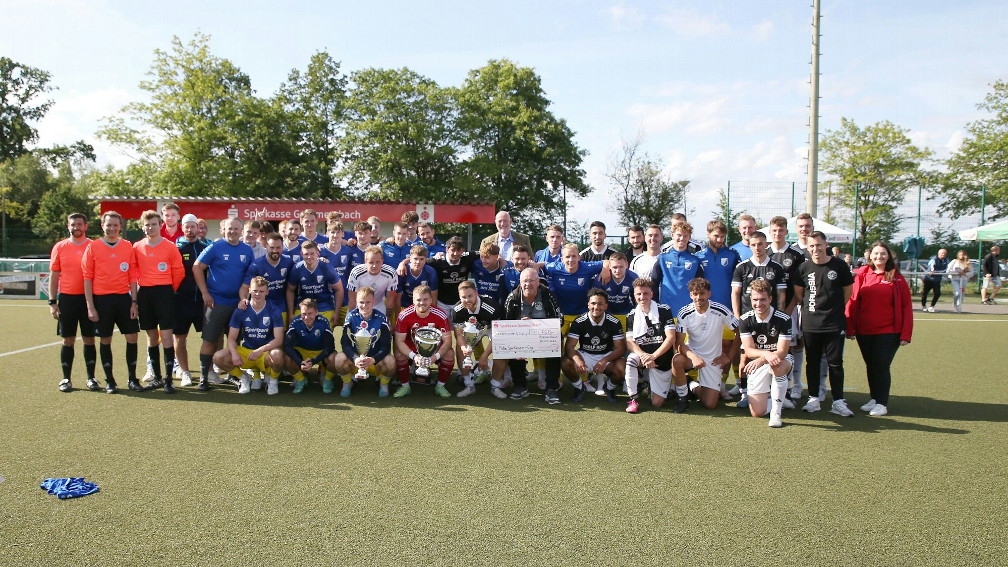 Die beiden Mannschaften des Endspiels, SSV Nümbrecht und Borussia Derschlag stehen in der Spielfeldmitte zum Foto.