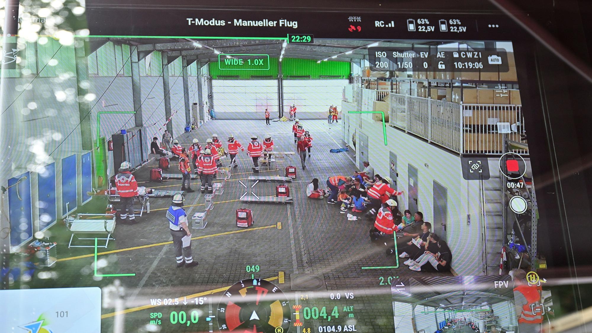 Auf einem Bildschirm ist die Einsatzstelle der DRK-Übung aus der Perspektive der eingesetzten Drohne zu sehen.