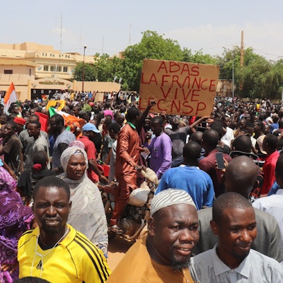 Niger, Niamey: Demonstranten nehmen an einem Marsch zur Unterstützung der Putschisten in der Hauptstadt teil, in der Mitte ein Schild mit der Aufschrift ‚Nieder mit Frankreich, es lebe der CNSP‘ ('Nationaler Rat für den Schutz des Vaterlandes'