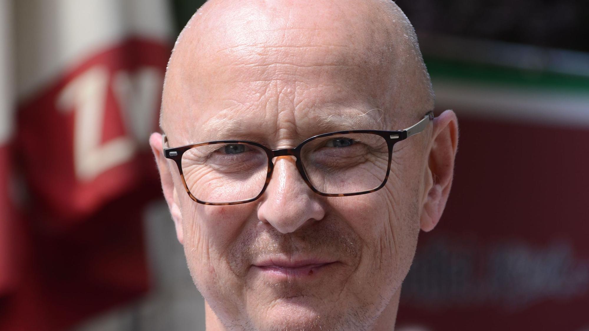 Ein Mann mit einer Brille blickt in die Kamera.