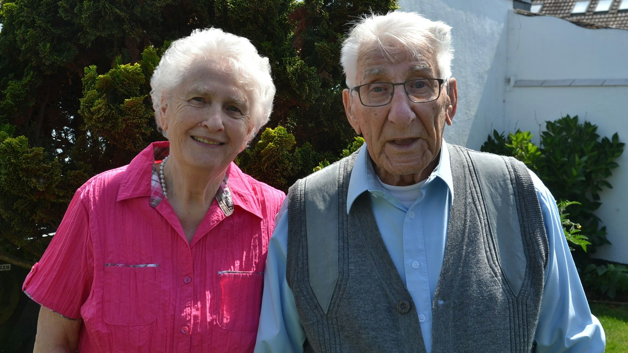 Das hochbetagte Paar blickt lächelnd in die Kamera.