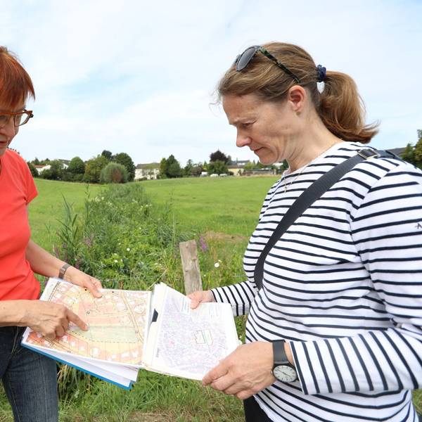Zwei Frauen stehen auf einer Wiese.