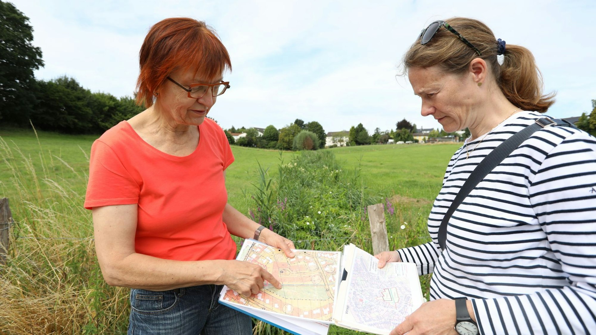 Zwei Frauen stehen auf einer Wiese.
