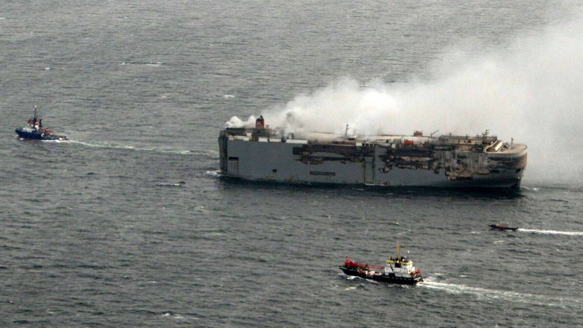 Die brennende „Fremantle Highway“ wird vor der niederländischen Küste von anderen Schiffen begleitet.