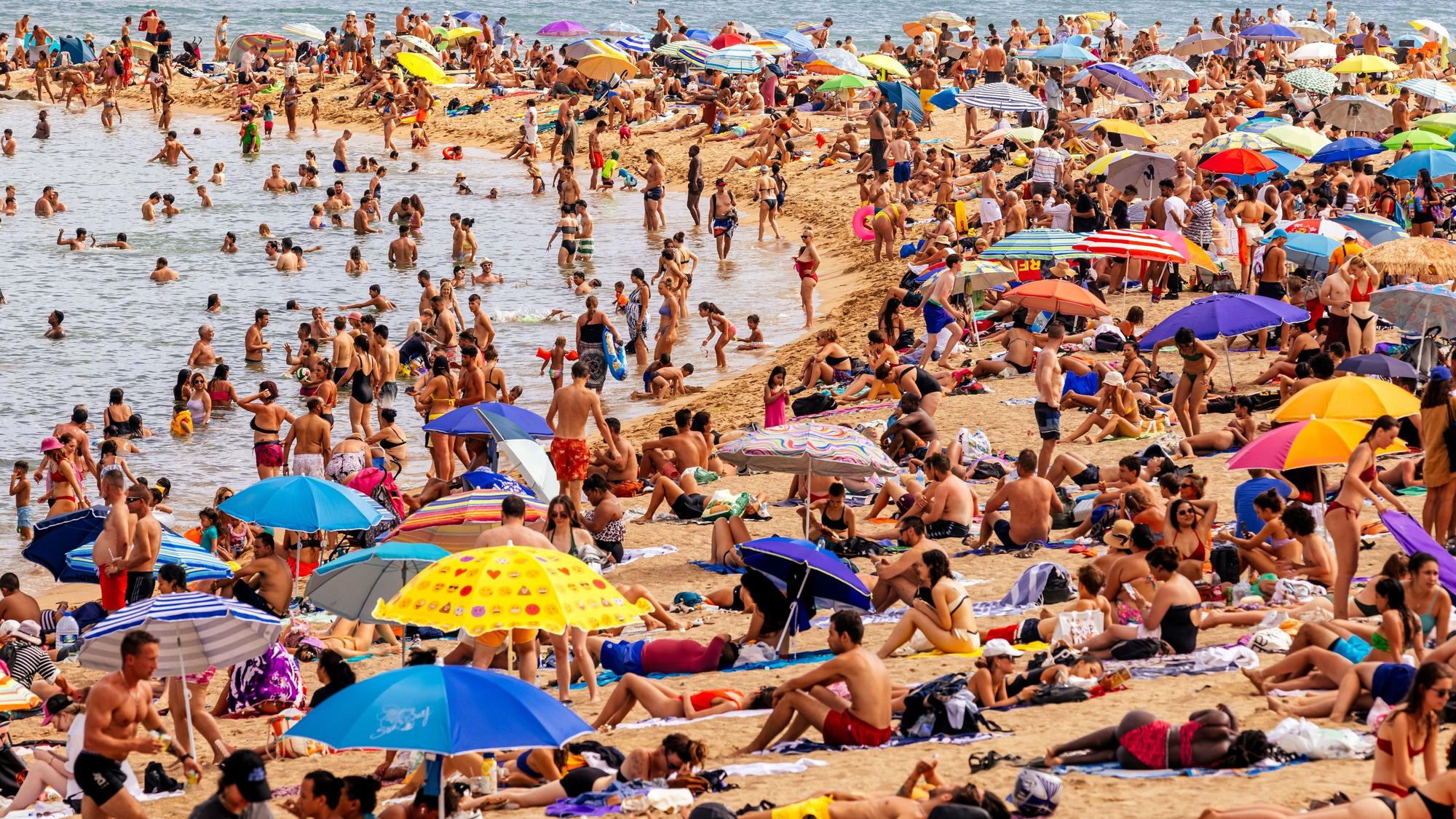 Touristen am Strand von Barceloneta.