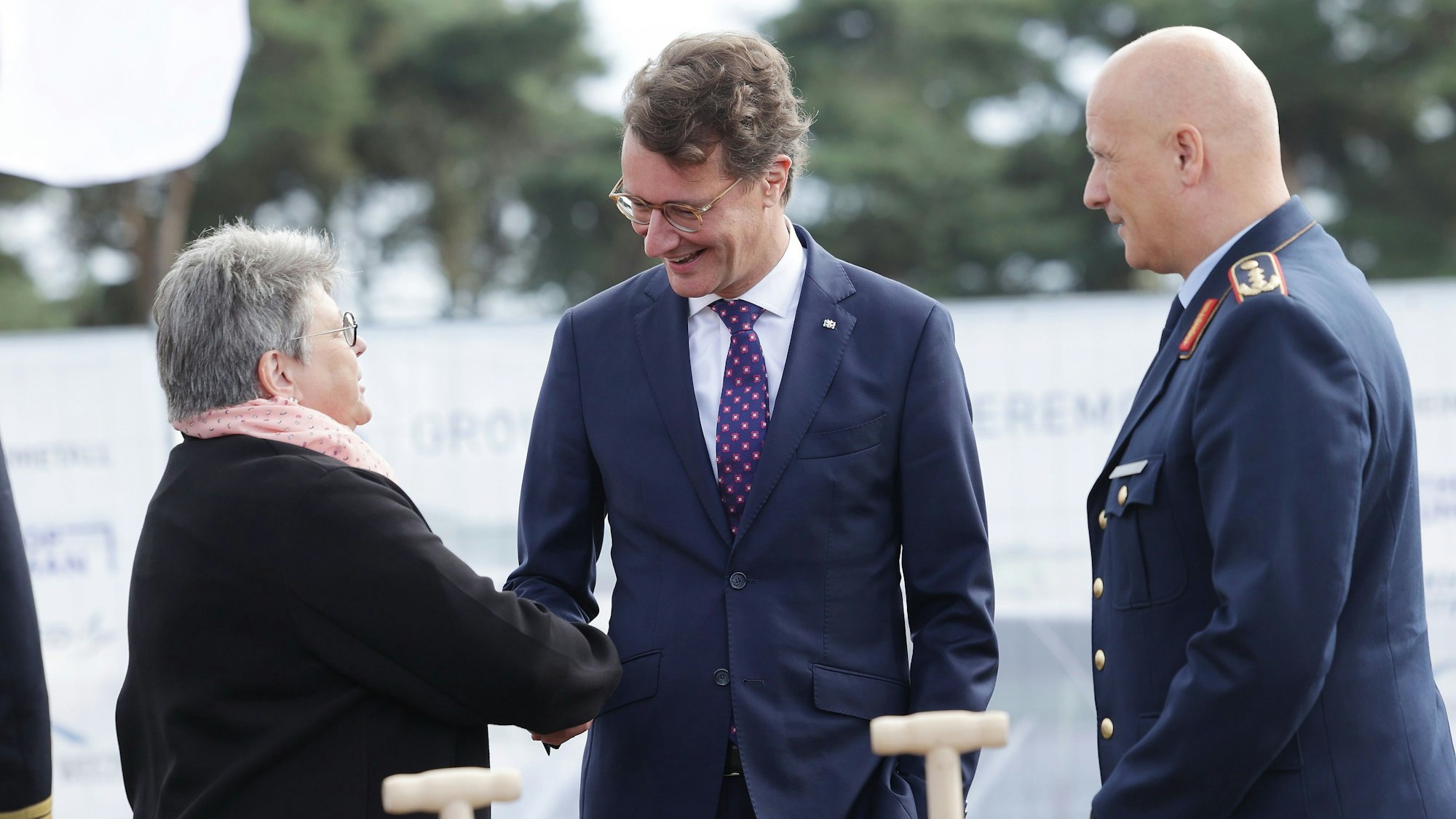 Annette Lehnigk-Emden, Präsidentin des Bundesamtes für Ausrüstung Informationstechnik und Nutzung der Bundeswehr, spricht mit Hendrik Wüst (M, CDU), Ministerpräsident von Nordrhein-Westfalen, und Ingo Gerhartz, Generalleutnant und Inspekteur der Luftwaffe, beim symbolischen ersten Spatenstich auf dem Niederrhein-Airport Weeze.
