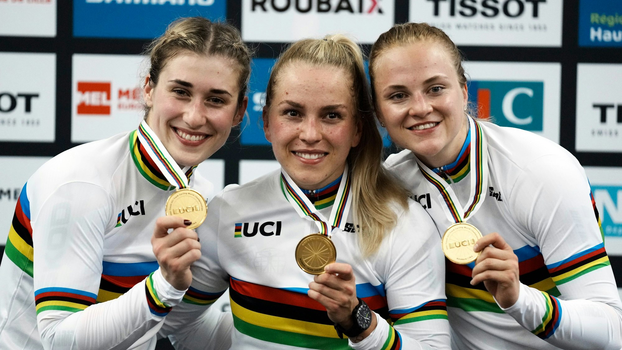 20.10.2021, Frankreich, Roubaix: Radsport/Bahn: Weltmeisterschaft, Teamsprint, Frauen: Pauline Sophie Grabosch aus Deutschland (l.), Lea Sophie Friedrich (r.) und Emma Hinze aus Deutschland zeigen ihre Goldmedaillen nach dem Sieg. Bei der WM in Glasgow wollen sie ihren Titel erfolgreich verteidigen.