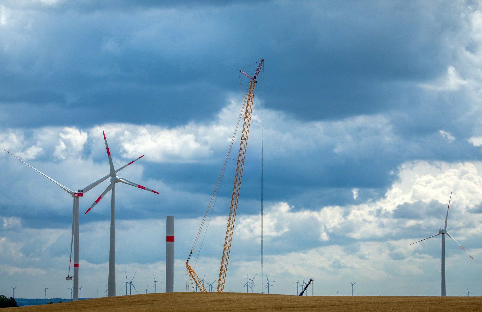 18.07.2023, Mecklenburg-Vorpommern, Radegast: Ein Kran arbeitet auf der Baustelle eines neuen Windparks.