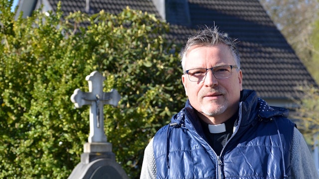 Der alt-katholische Geistliche Michael Schenk stammt aus Waldbröl und gehört zu den Opfern sexuellen Missbrauchs durch katholische Geistliche. Hier sitzt er an einem Rondell vor seinem Therapie- und Exerzitien-Hof Aim Karem in Ruppichteroth-Stranzenbach.