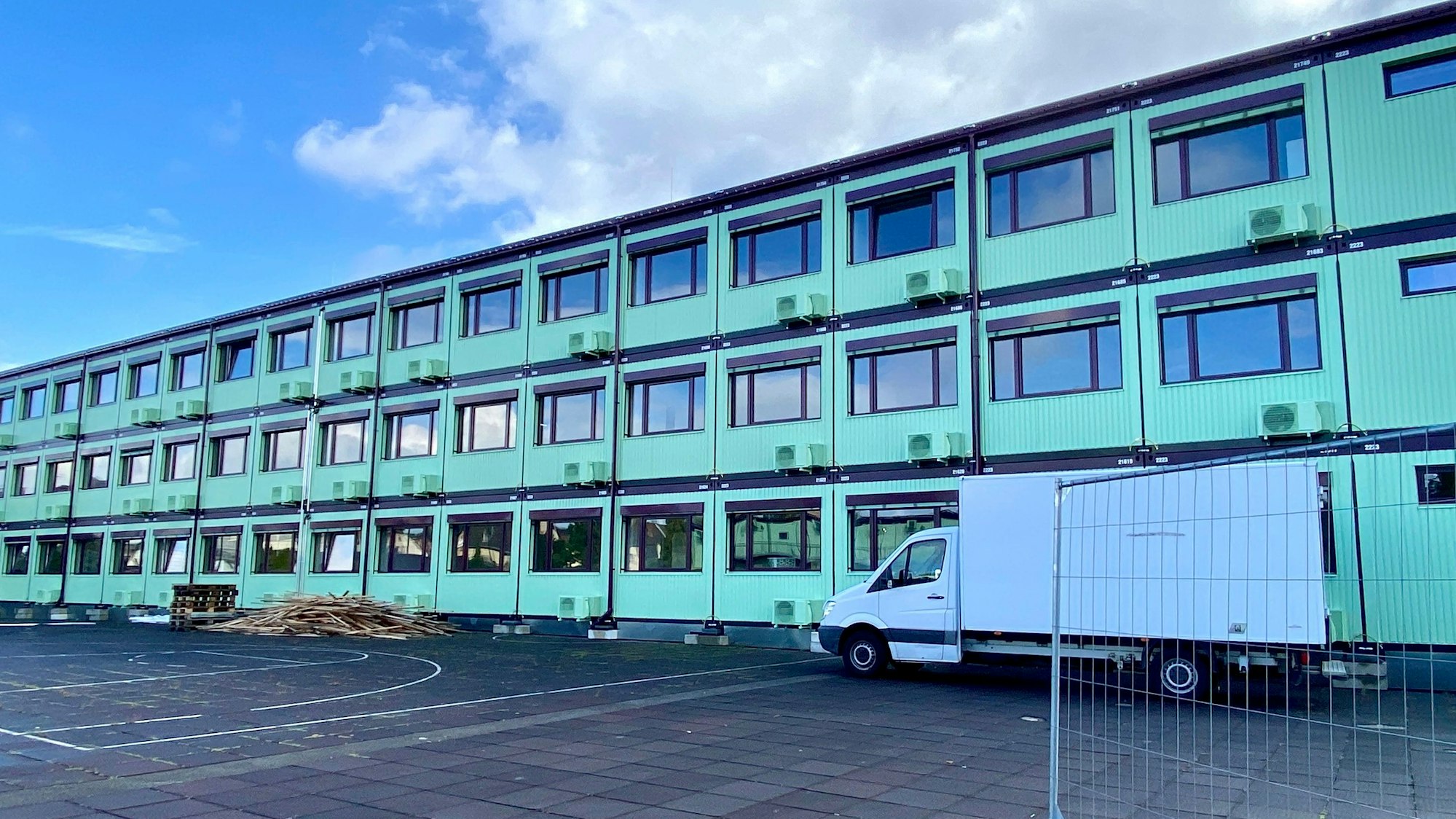 Das Bild zweigt Schulcontainer, die in drei Reihen übereinander gestapelt sind.
