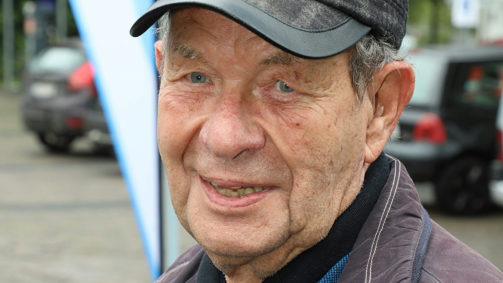 Ein Mann mit Kappe schaut in die Kamera.