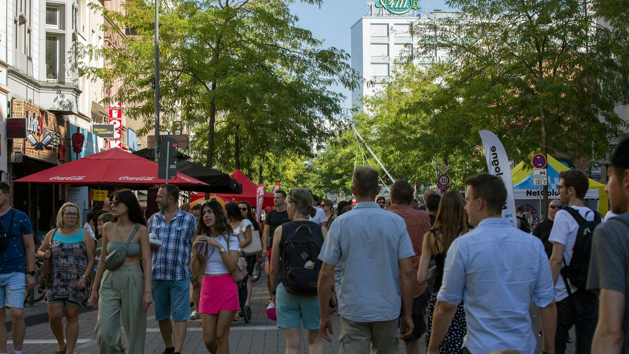 Viele Menschen laufen über die für Autos gesperrte Venloer Straße.