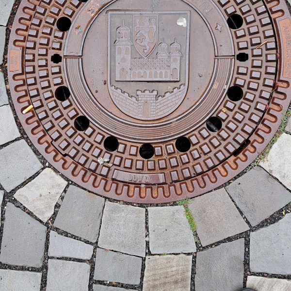 Das Bild zeigt einen Kanaldeckel mit dem Wipperfürther Stadtwappen und dem Schriftzug „Stadt Wipperfürth“.