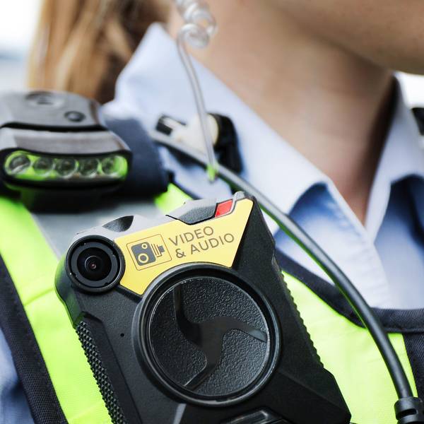 Eine Polizistin der Streifenpolizei führt eine Bodycam vor.