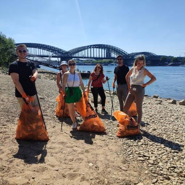 Mitarbeitende der Zurich Gruppe Deutschland beim Müllsammeln am Rhein.