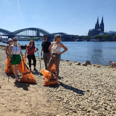 Mitarbeitende der Zurich Gruppe Deutschland beim Müllsammeln am Rhein.