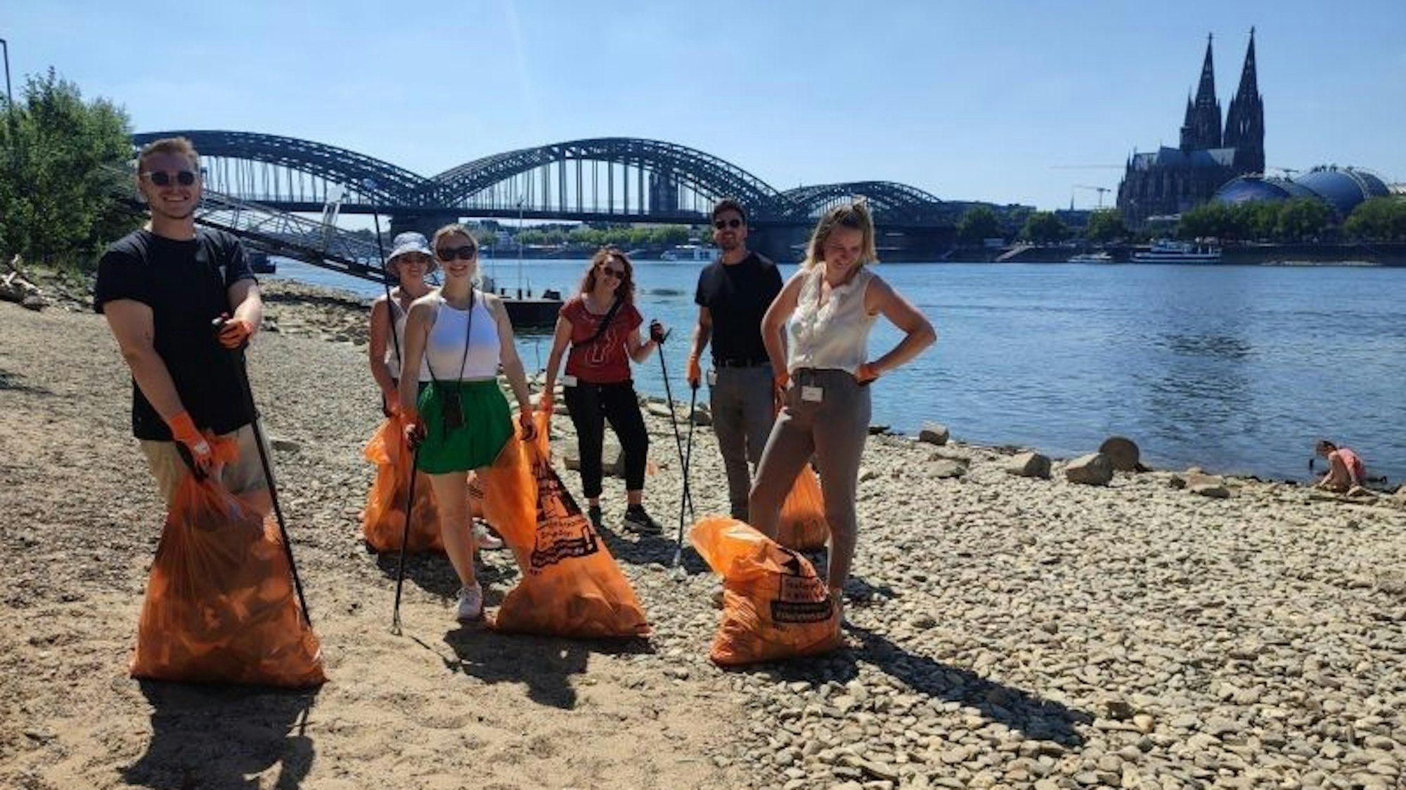 Mitarbeitende der Zurich Gruppe Deutschland beim Müllsammeln am Rhein.