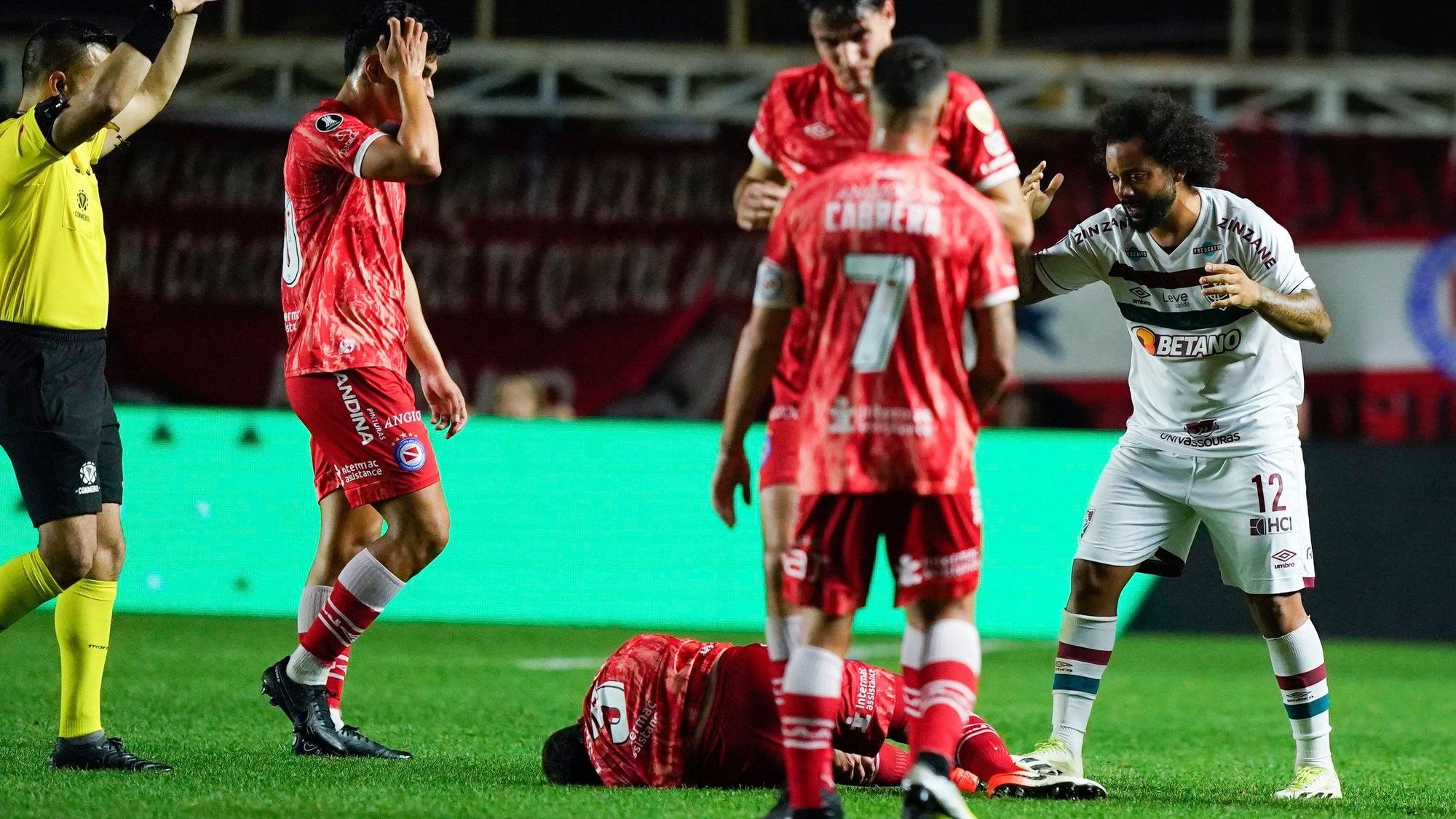 Luciano Sanchez (u.) liegt auf dem Boden, nachdem er sich bei einem Zweikampf mit Marcelo (r.) im Achtelfinal-Hinspiel der Copa Libertadores das Knie verdreht hat.