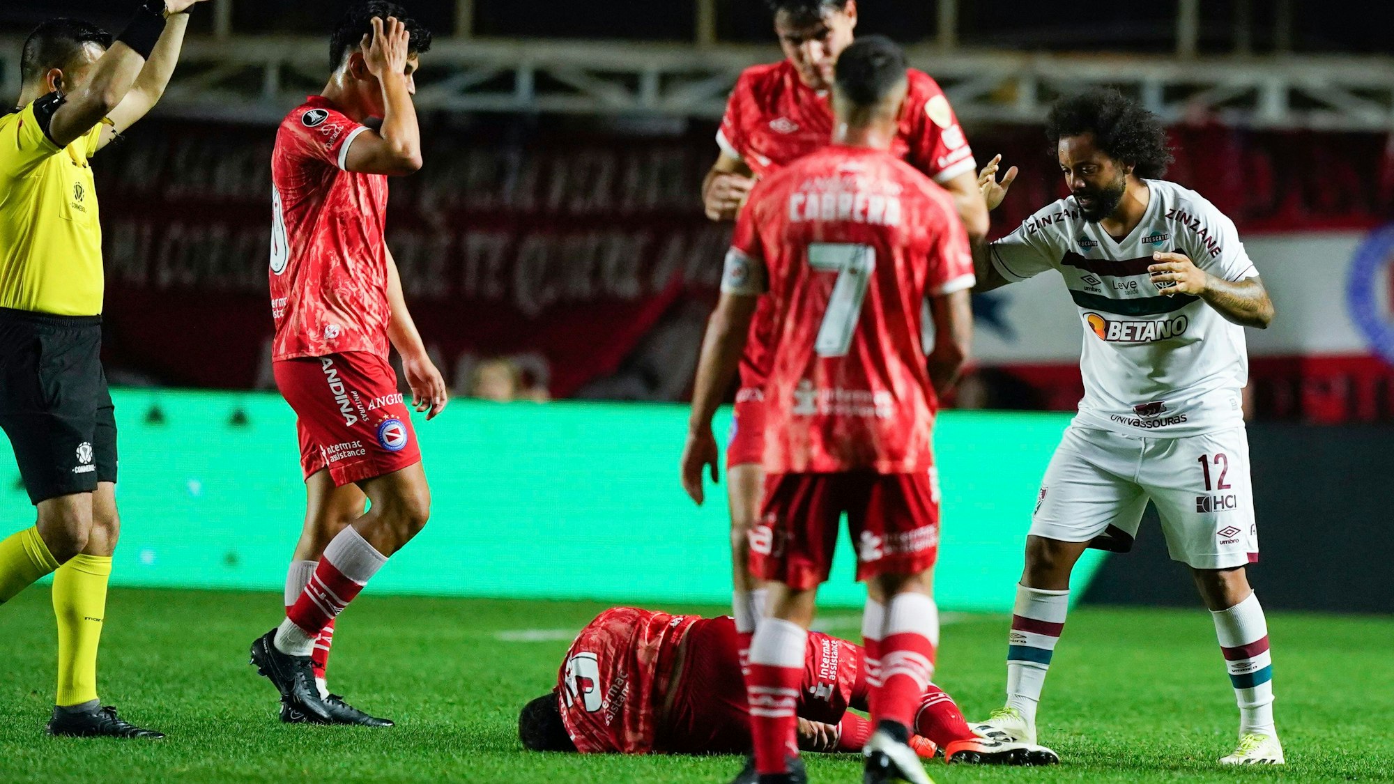 Luciano Sanchez (u.) liegt auf dem Boden, nachdem er sich bei einem Zweikampf mit Marcelo (r.) im Achtelfinal-Hinspiel der Copa Libertadores das Knie verdreht hat.