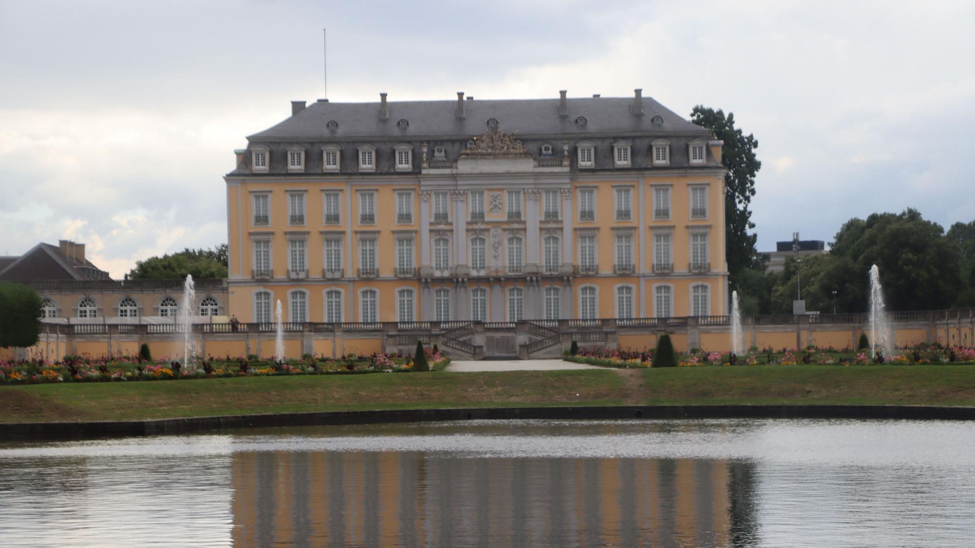 Die Fassade von Schloss Augustusburg ist auf der Wasseroberfläche eines Teichs zu sehen.