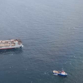 Eine Luftaufnahme zeigt den havarierten und brennenden Frachter „Fremantle Highway“ in der Nordsee vor den Inseln Schiermonnikoog und Ameland. Um ihn herum fahren mehrere Schlepper.