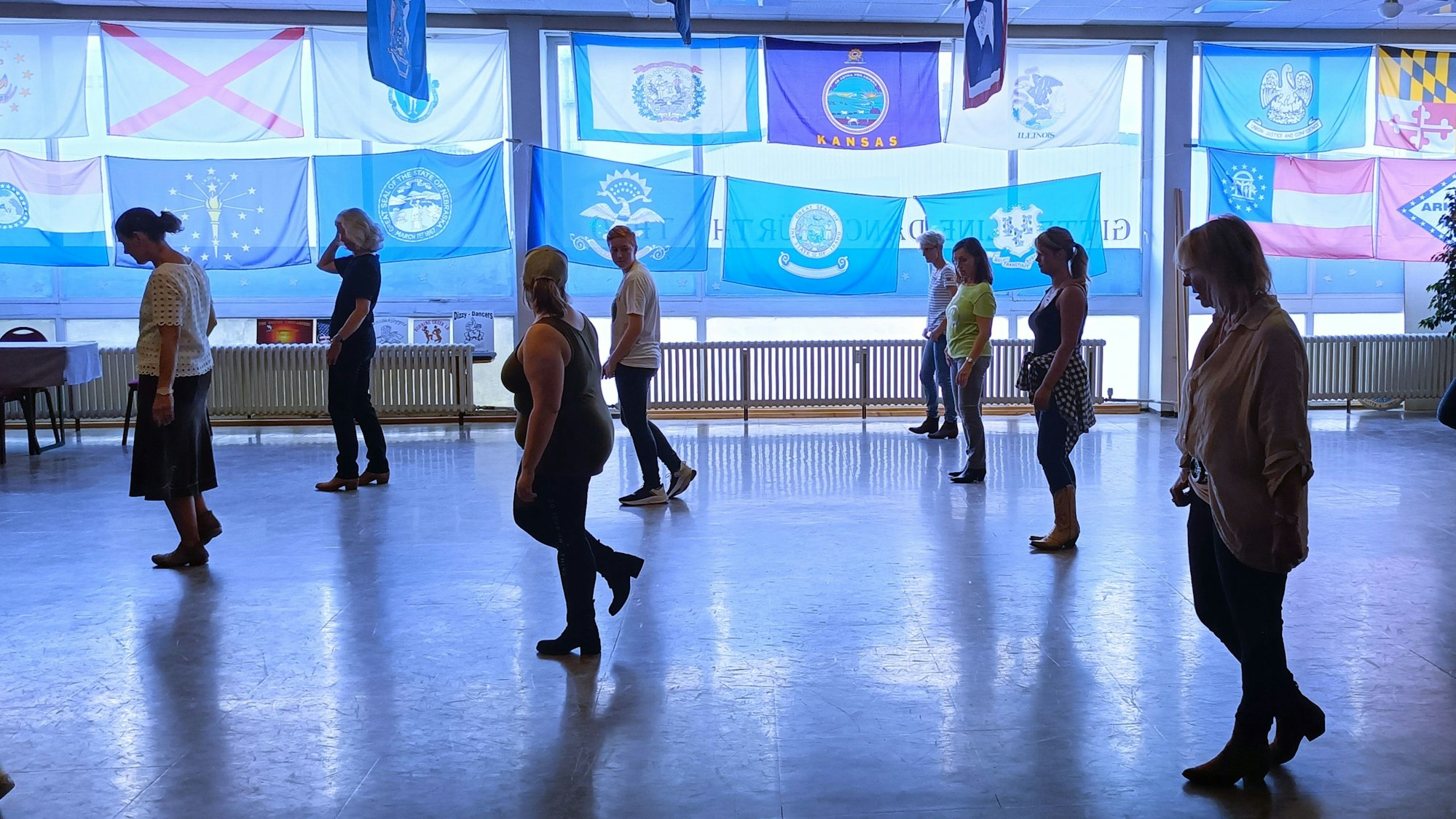 Mehrere Frauen tanzen in Reihen hintereinander.