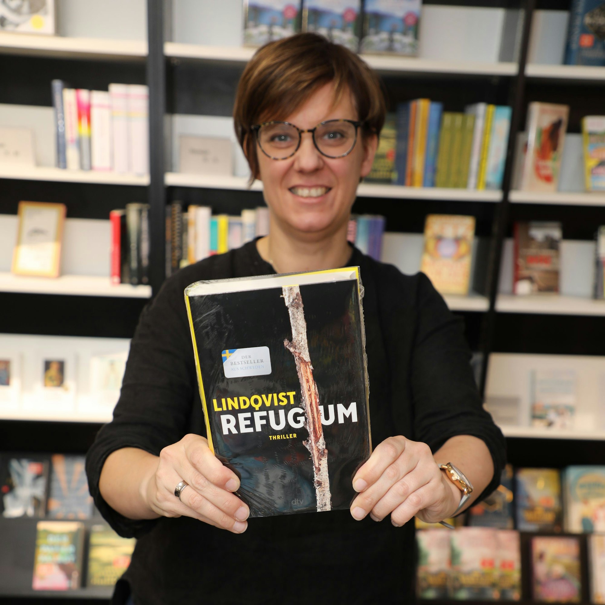 Pia Patt von der Buchhandlung Funk in Bensberg hält ein Buch in den Händen.