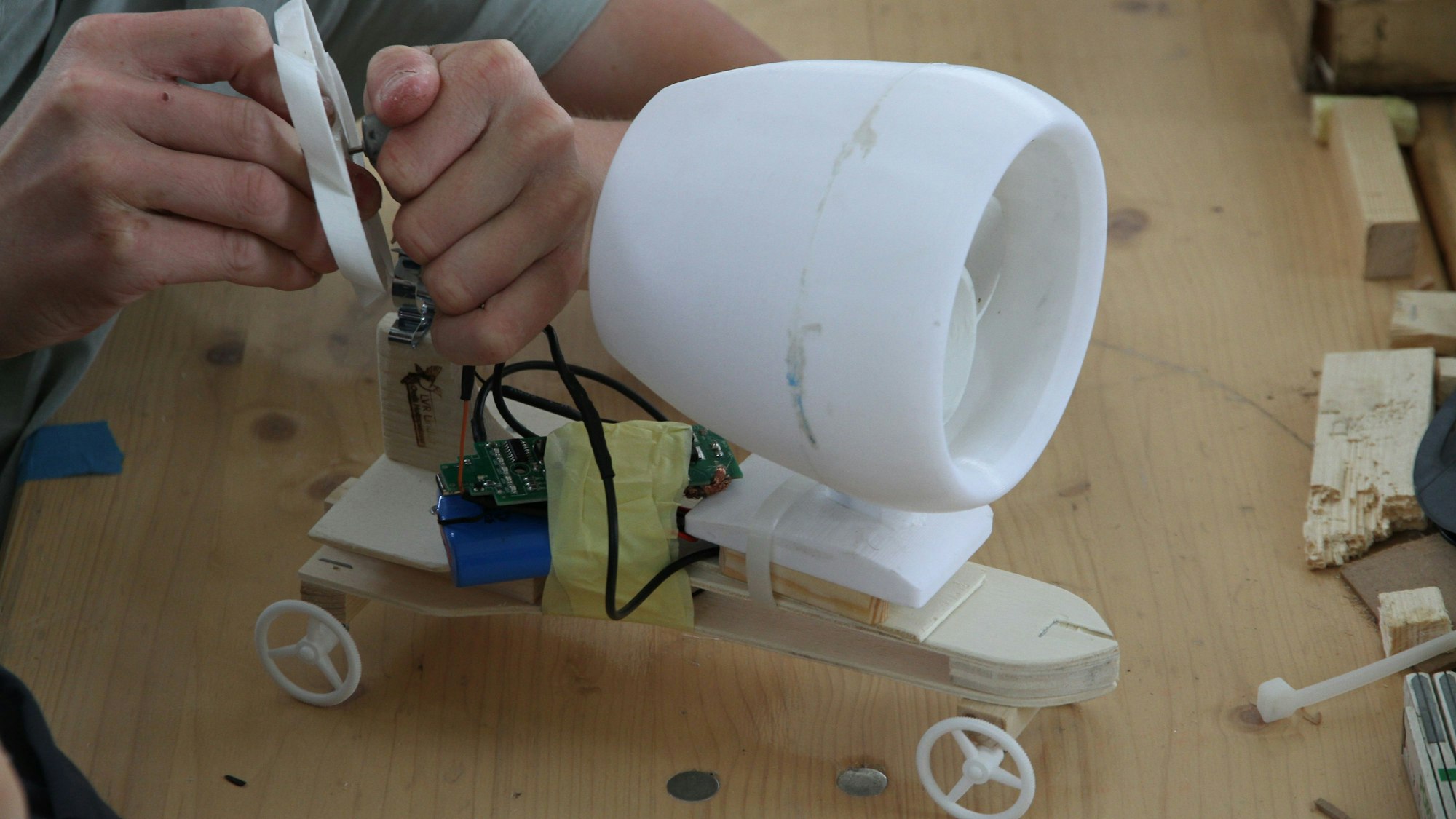 Ein kleines Batteriemobil wird voin einem Propeller in einem weißen Gehäuse angetrieben