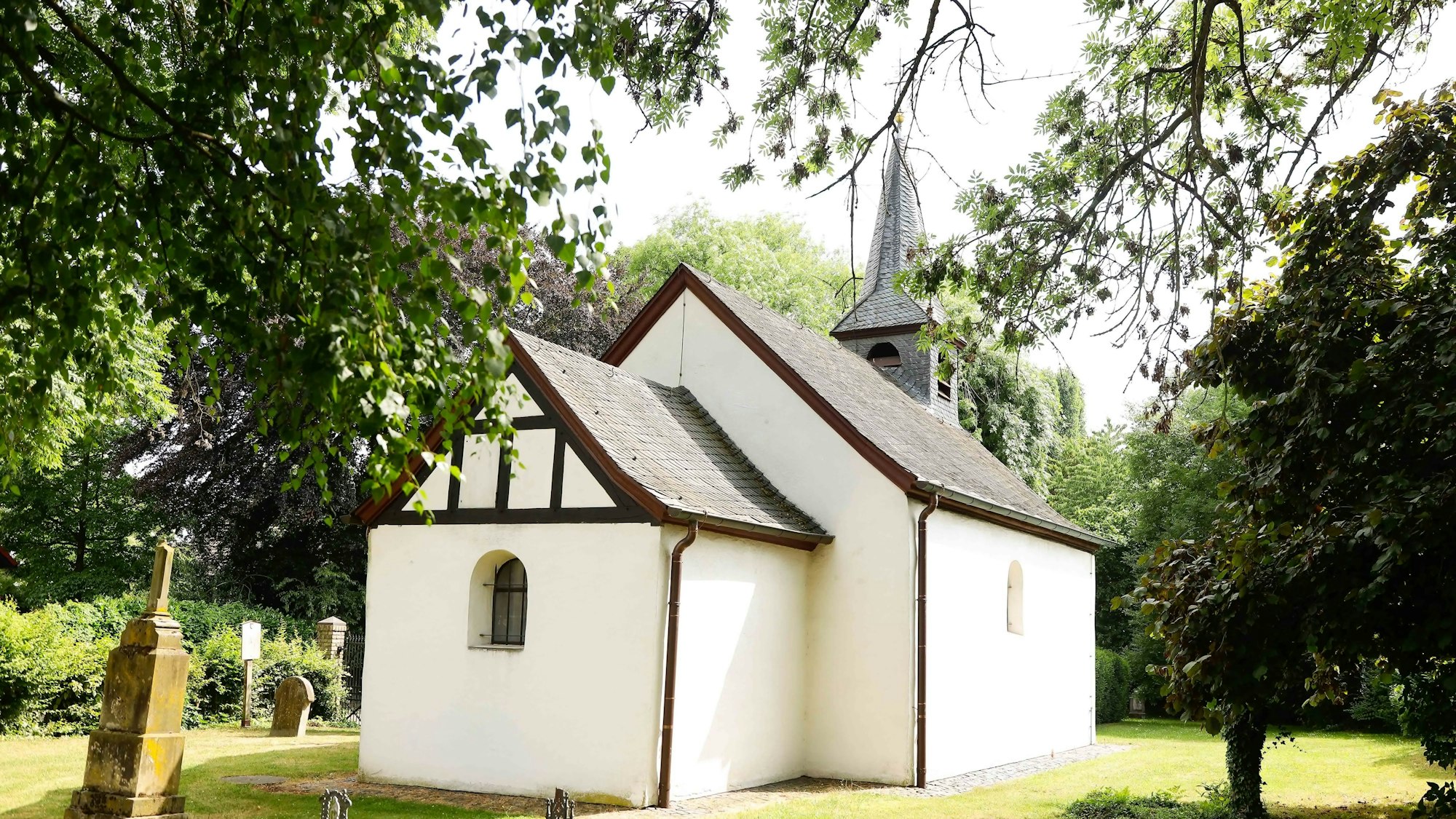 Die Nikolauskapelle in Westhoven inmitten eines aufgegebenen Friedhofs.