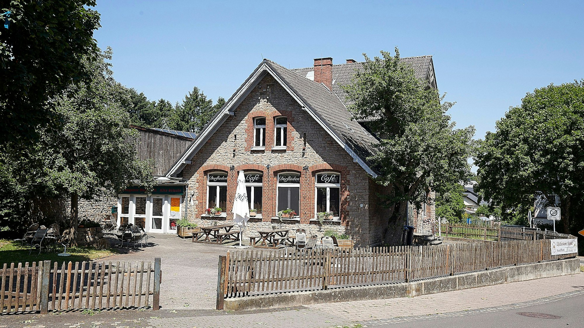 Das Foto zeigt den Dorftreff, der in der Alten Schule untergebracht ist. Davor ungenutzte Tische und Bänke.