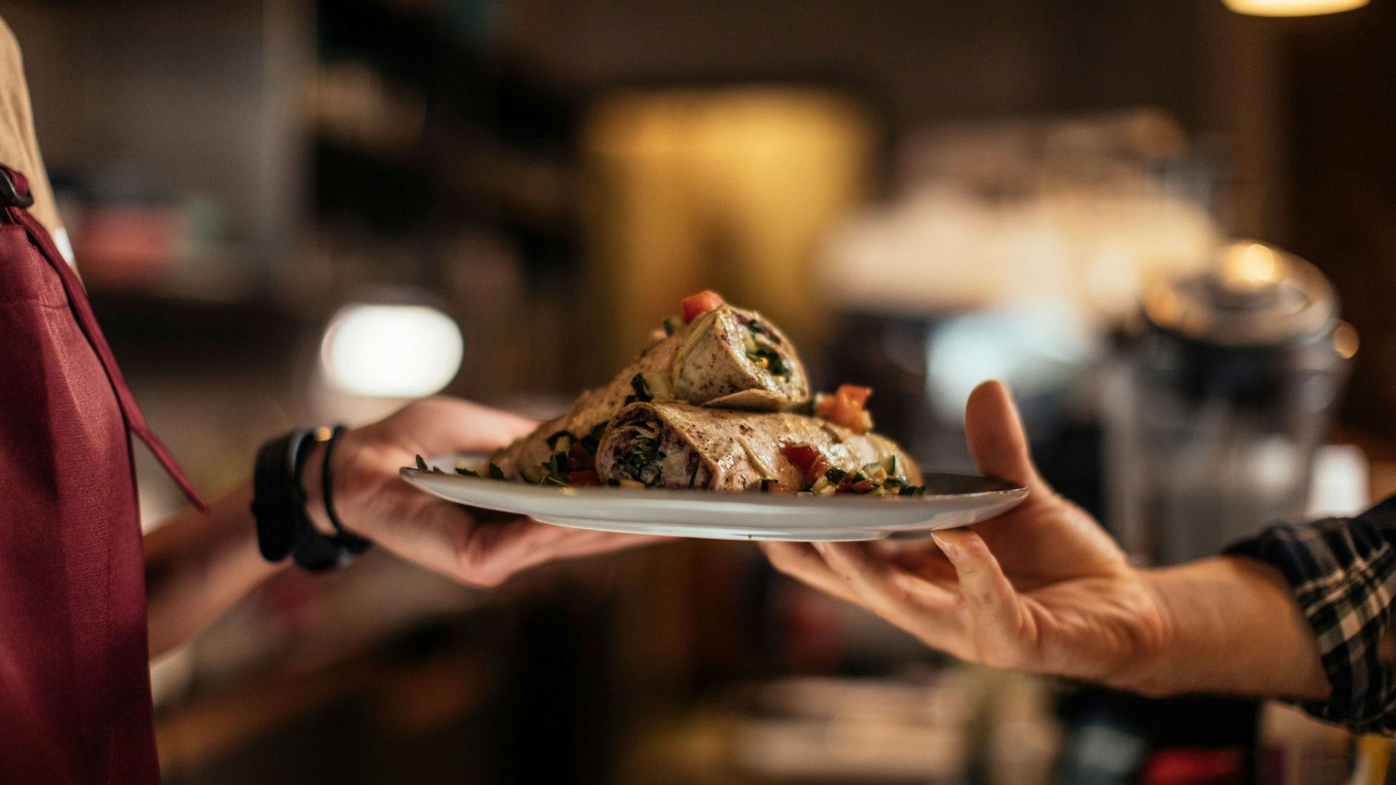 Ein Teller mit Essen wird in einem Restaurant übergeben