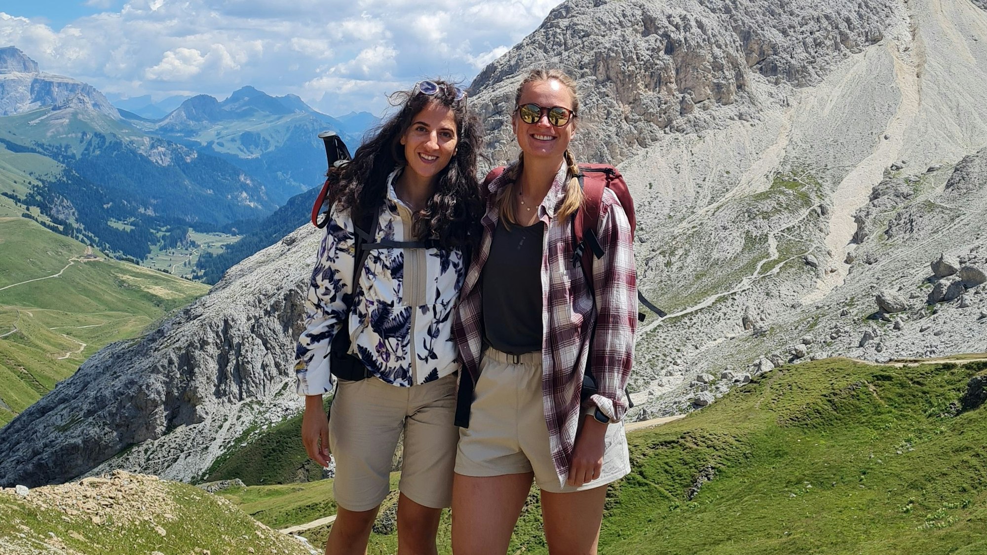 Zwei junge Frauen stehen in den Bergen.