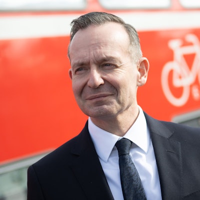 Volker Wissing steht während einer Besichtigung der Bahnstrecke Mannheim-Frankfurt am Bahnhof Lampertheim neben dem Fahrradabteil eines Regional-Expresses.