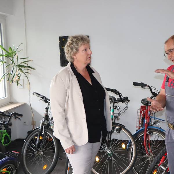 Beate Schnitzler und Jürgen Schnitzler unterhalten sich in der Werkstatt, um sie herum stehen viele Drahtesel.