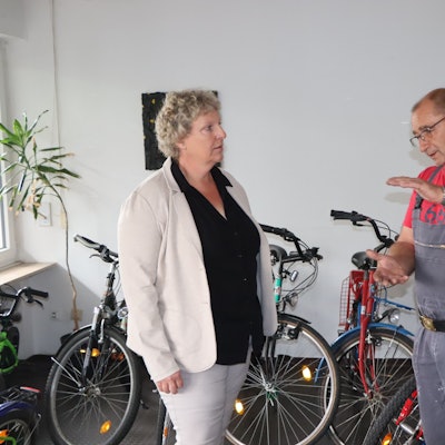 Beate Schnitzler und Jürgen Schnitzler unterhalten sich in der Werkstatt, um sie herum stehen viele Drahtesel.