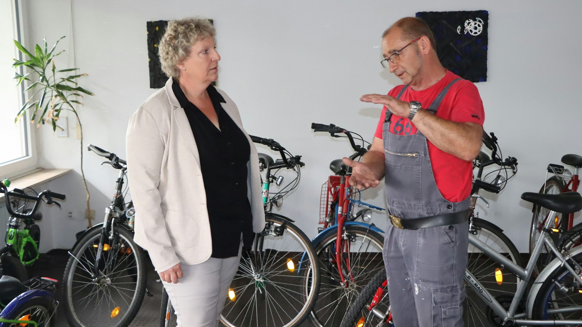 Beate Schnitzler und Jürgen Schnitzler unterhalten sich in der Werkstatt, um sie herum stehen viele Drahtesel.