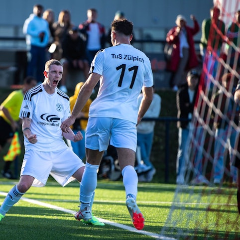 Zülpichs Fußballer Dominik Spies jubelt mit Torschütze Luca Ohrem.
