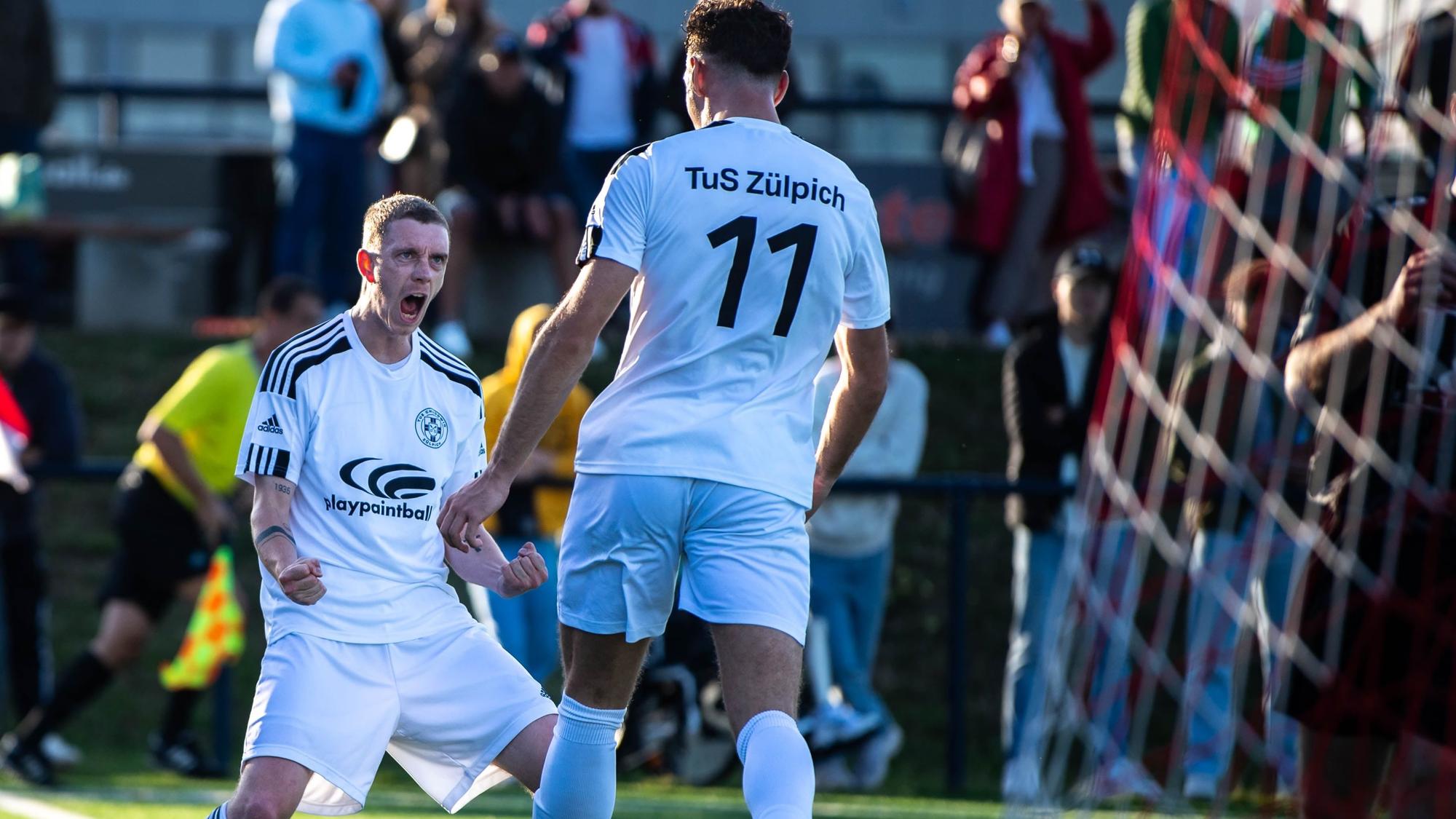 Zülpichs Fußballer Dominik Spies jubelt mit Torschütze Luca Ohrem.