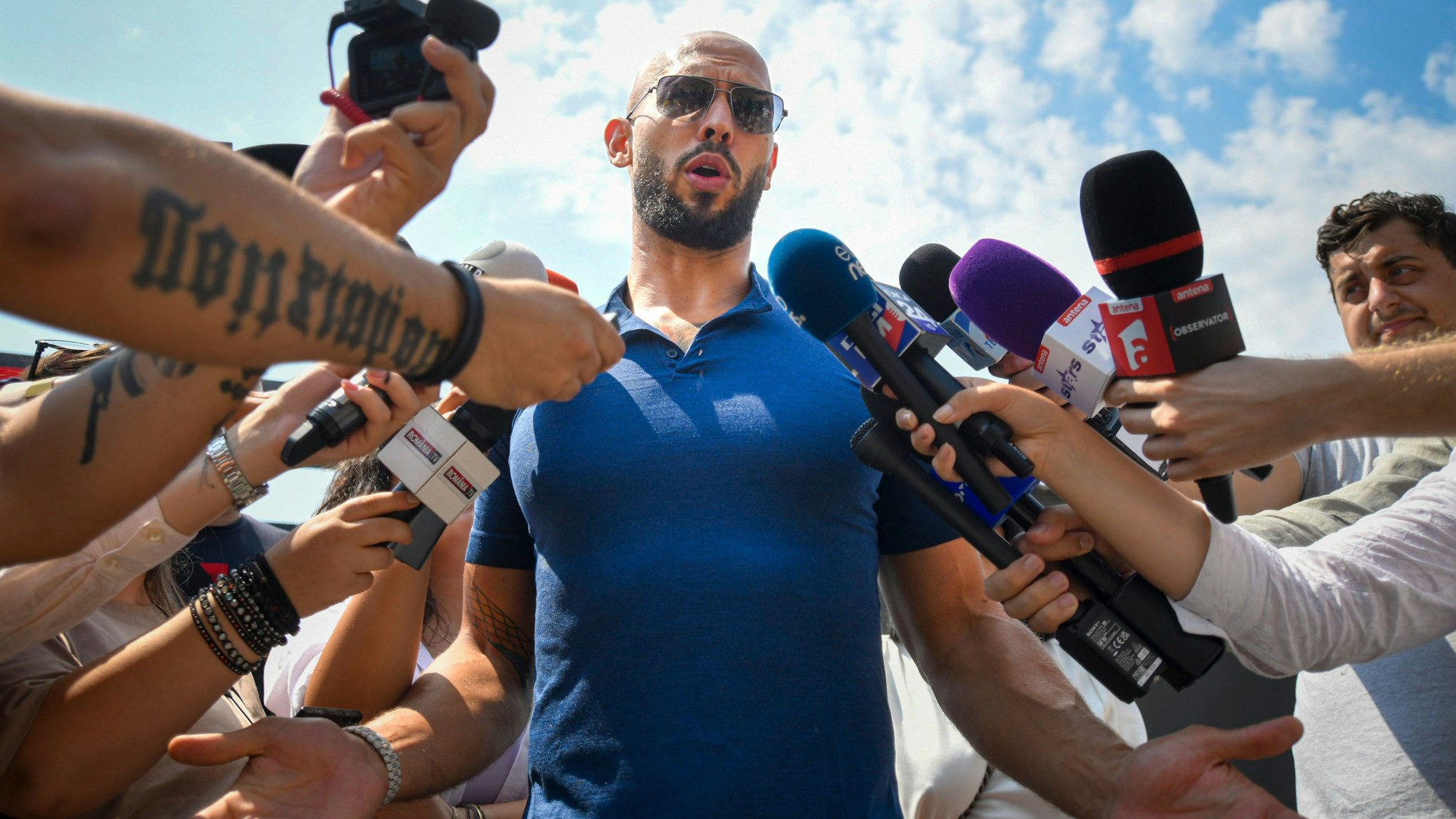 Andrew Tate spricht am Freitag zu Reportern, nachdem er aus dem Hausarrest entlassen wurde.