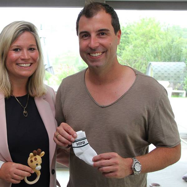 Jennifer Meuren hält ein kleines Spielzeug in der Hand, ihr Ehemann Krishan Babysöckchen. Sie freuen sich auf die Geburt ihres ersten Kindes im Oktober.
