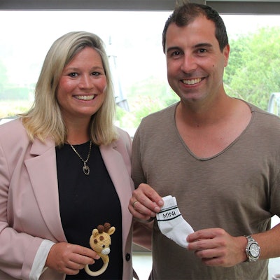 Jennifer Meuren hält ein kleines Spielzeug in der Hand, ihr Ehemann Krishan Babysöckchen. Sie freuen sich auf die Geburt ihres ersten Kindes im Oktober.