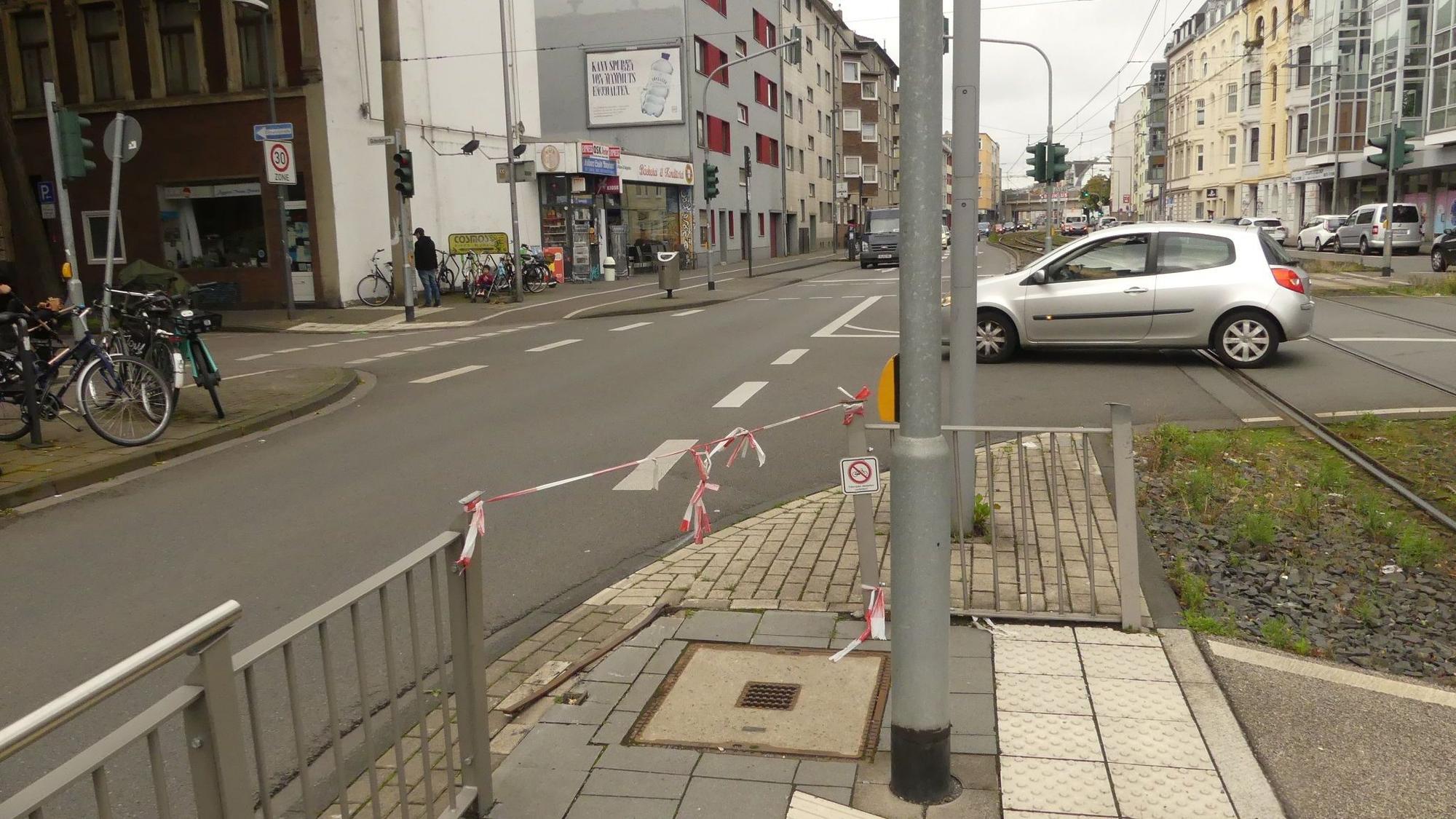 Am Gitter einer Straßenbahnhaltestelle ist Flatterband befestigt.