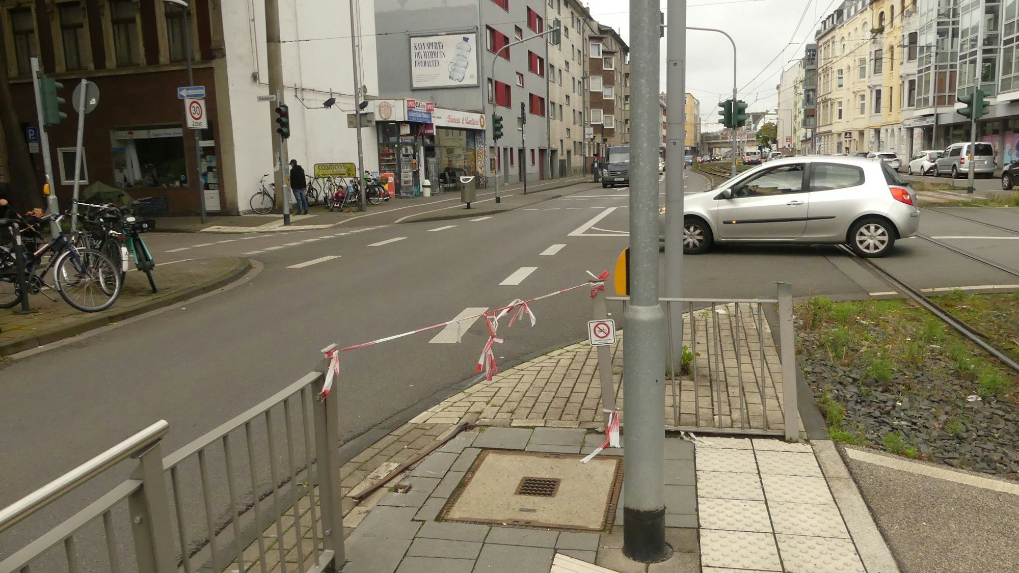 Am Gitter einer Straßenbahnhaltestelle ist Flatterband befestigt.