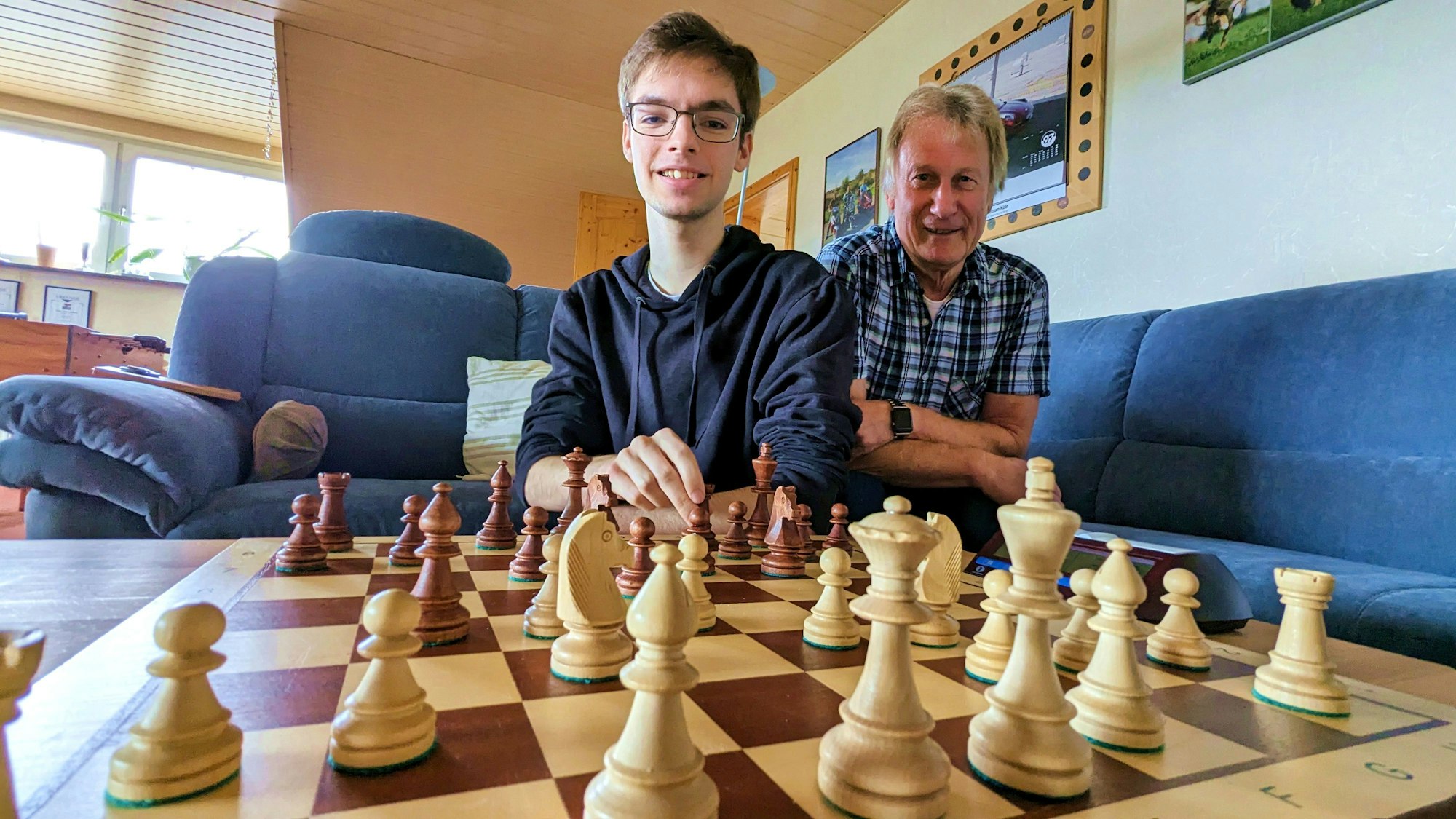 Zwei Schachspieler, Bela Voß (l.) und Heinz Schwarzhoff (r.), sitzen an einem Schachbrett mit aufgestellten Schachfiguren.