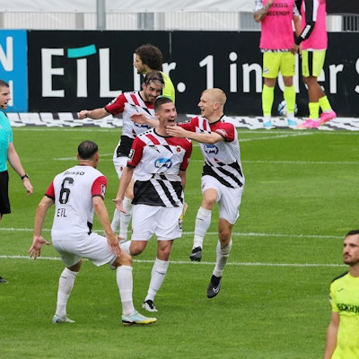 Die Spieler von Viktoria Köln freuen sich über ein Tor und feiern zusammen.