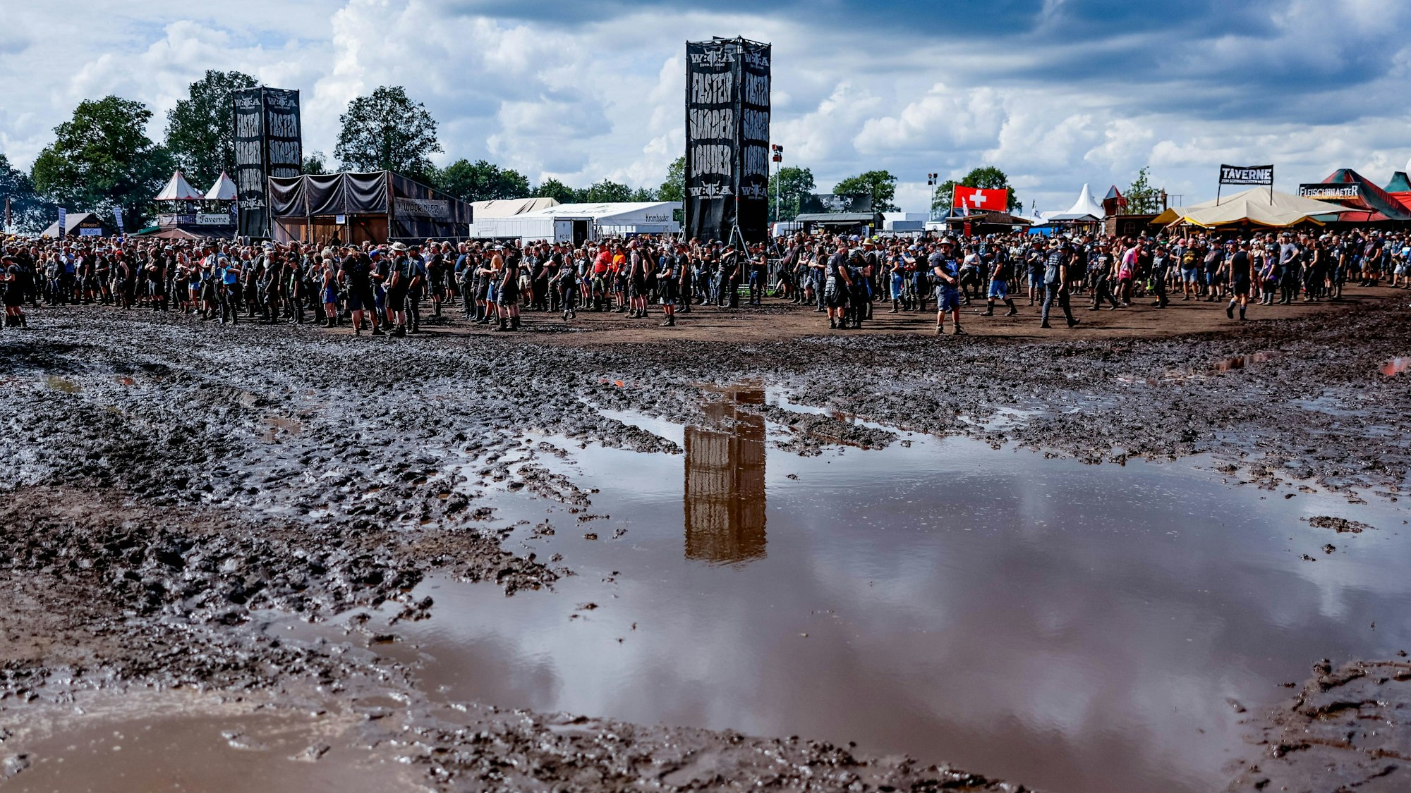 Schlammpfützen überziehen das Festival-Gelände des Wacken Open Air.