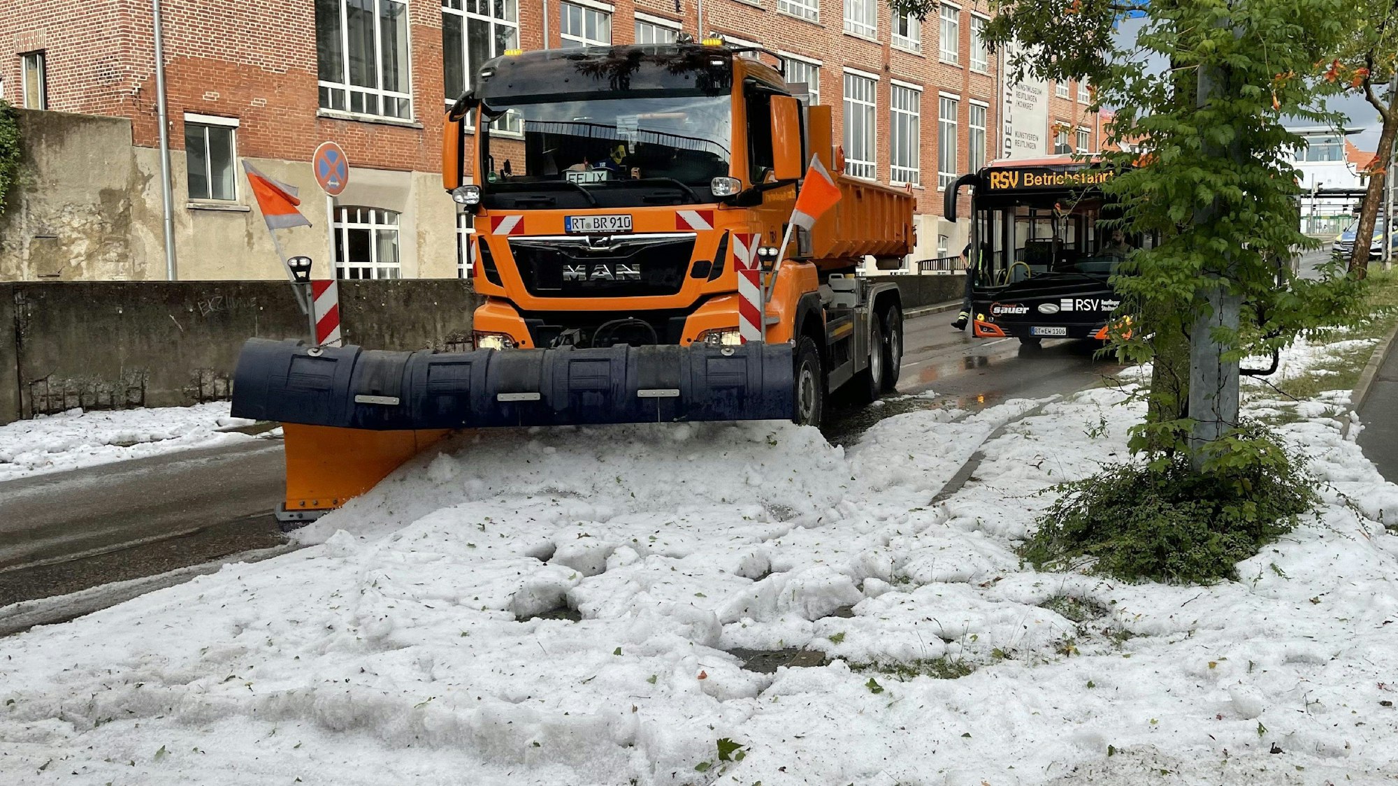 Die Technischen Betriebsdienste rücken mit Schneepflügen an um den Hagel von der Straße zu räumen.